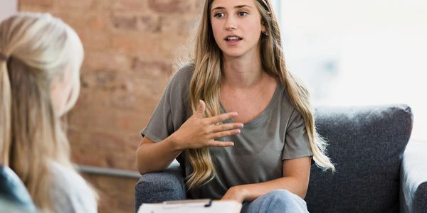 Woman in a counseling session, speaking with a therapist in a modern office
